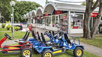 A row of go-karts parked in front of a building with a reception area and a shop.