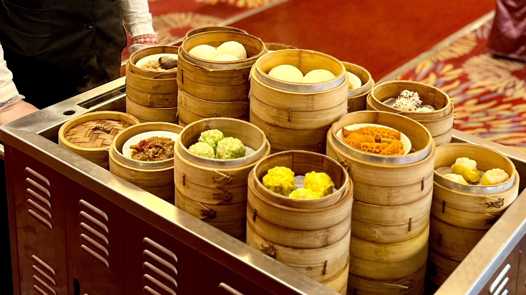Une variété de plats de dim sum servis dans des paniers à vapeur en bambou.