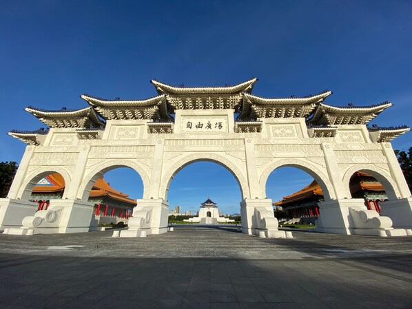 A traditional Chinese gate with intricate carvings and a clear blue sky above.