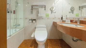 A modern bathroom with a glass-enclosed shower, a white toilet, a vanity with a sink, and two mirrors.