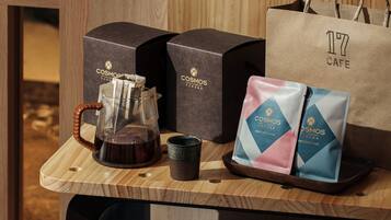 A coffee setup with a drip coffee bag, a glass carafe, and a cup on a wooden surface.