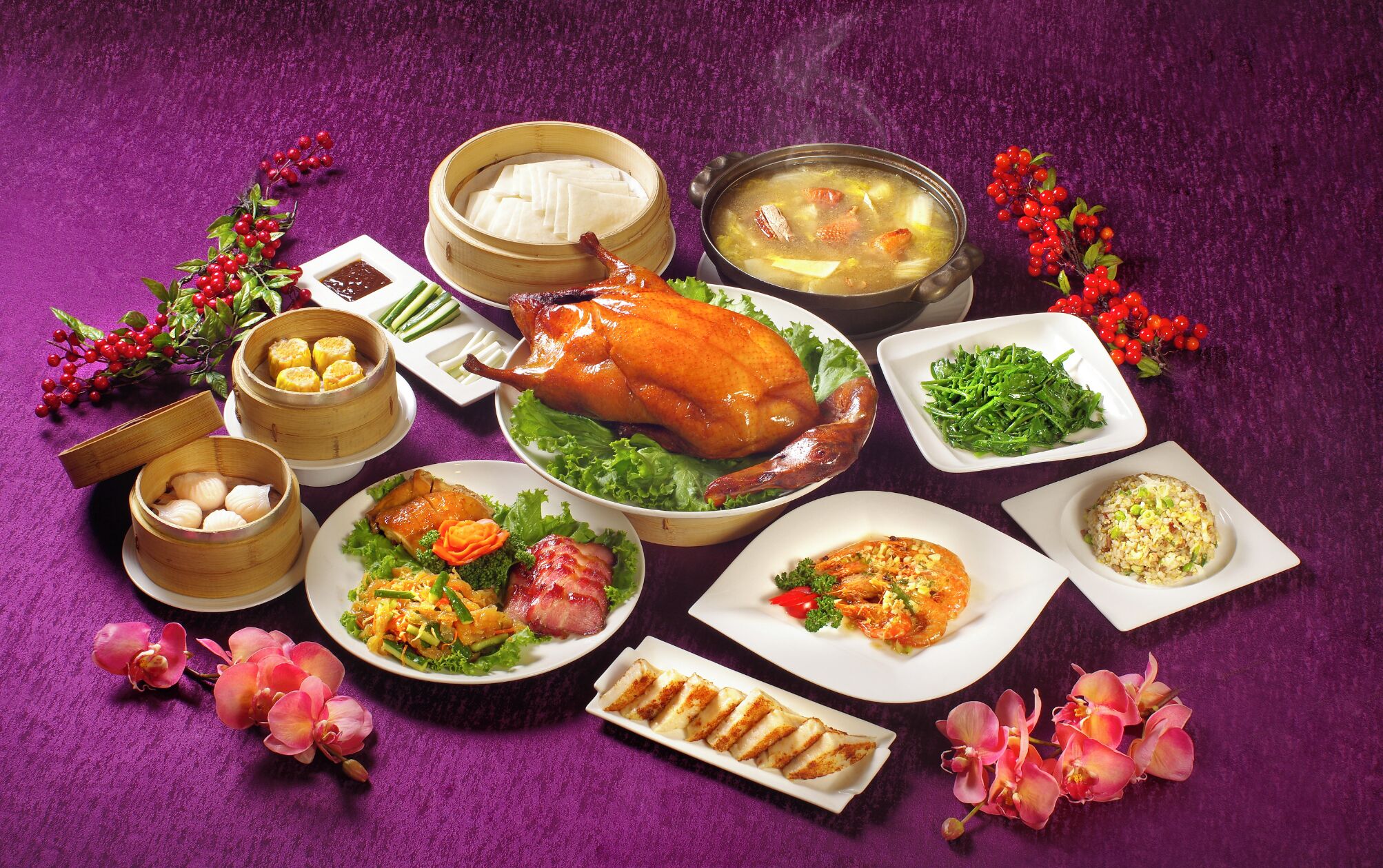 A variety of dishes including a roasted duck, dumplings, and a bowl of soup, arranged on a purple tablecloth.