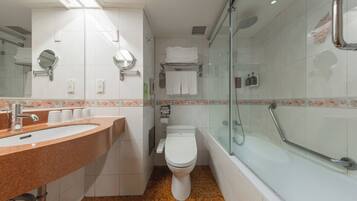 A modern bathroom with a granite sink, a toilet, and a glass-enclosed shower area.