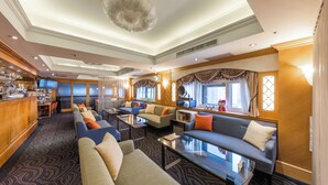 A spacious hotel lobby with a bar area, multiple seating options including sofas and armchairs, and a large chandelier. - Cosmos Hotel Taipei (Taipei)