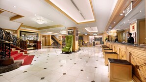 A spacious lobby with a grand staircase, a reception area, and a bar. - Cosmos Hotel Taipei (Taipei)
