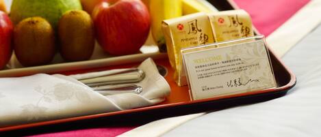 A tray with fruits, a napkin, and a welcome card on a table.