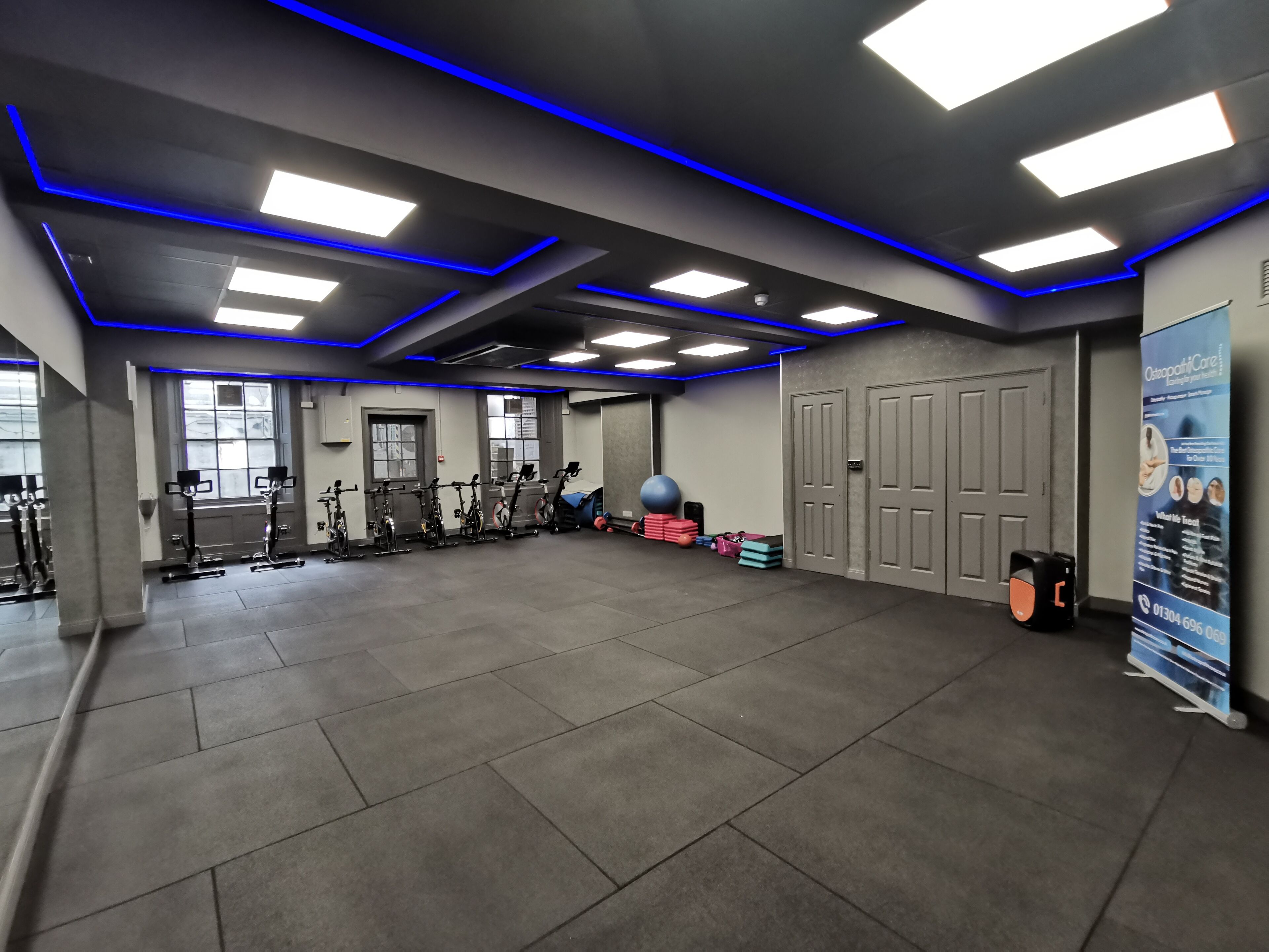 A gym with exercise equipment, a large exercise ball, and a poster on the wall.