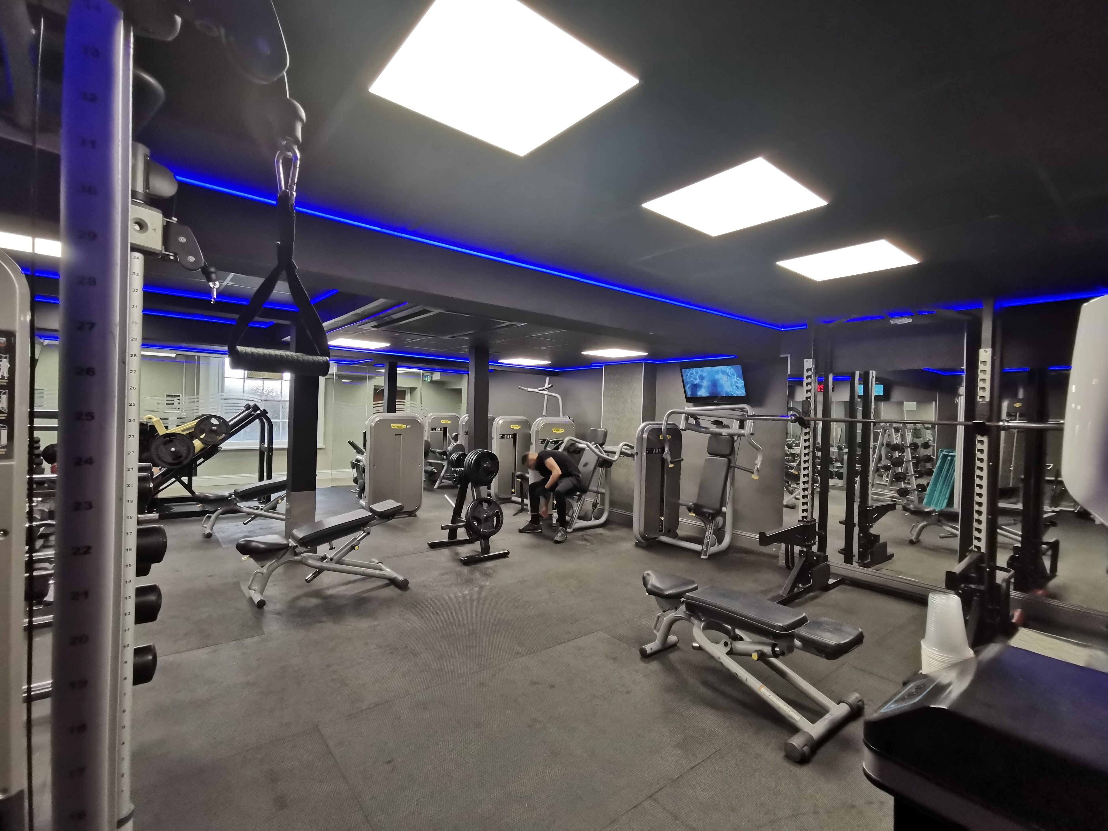 A gym with various exercise equipment, including weight machines and free weights.