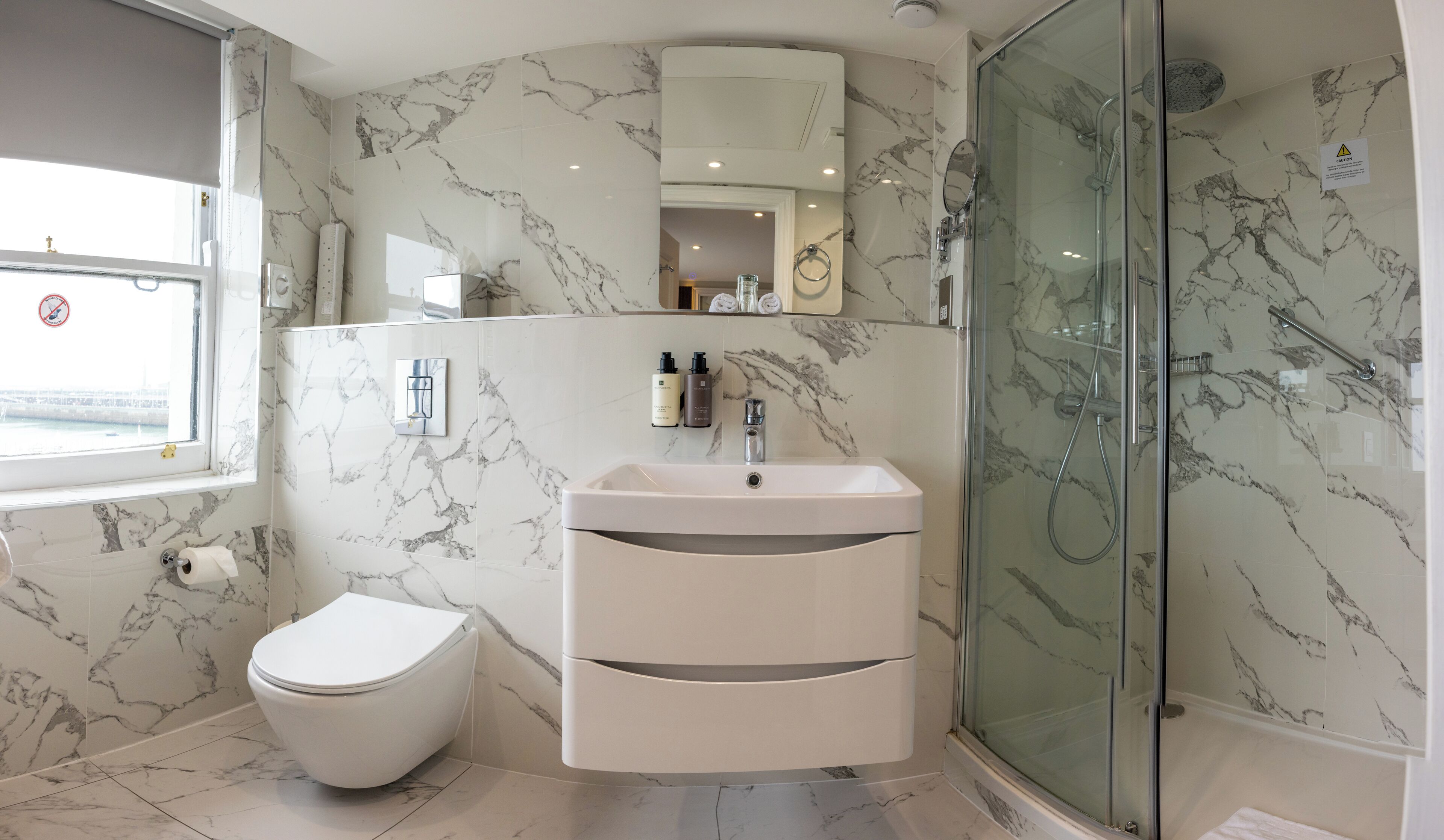 A bathroom with a toilet, sink, and glass-enclosed shower.