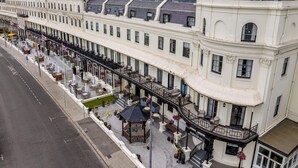 Een rij witte gebouwen met balkons, een centraal gelegen tuin en een bord met de tekst Winston Hall.