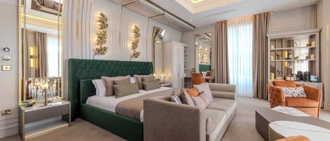 A spacious hotel room with a large bed, a sofa, a coffee table, and a seating area.