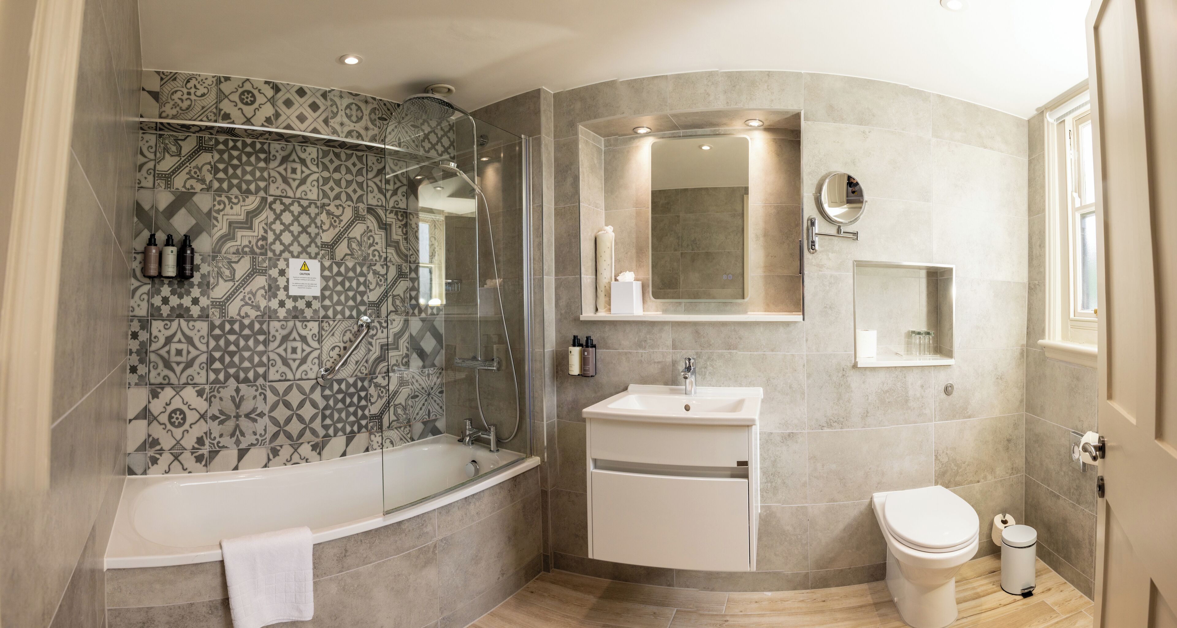A modern bathroom with a freestanding bathtub, a glass-enclosed shower, a vanity with a sink, and a toilet.