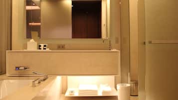 A modern bathroom with a large mirror, a sink, and a towel rack.