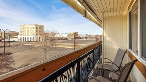 Ein Balkon mit Blick auf ein Gebäude und einen Parkplatz.