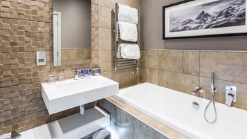 Un baño moderno con lavabo integrado, bañera y perchero.