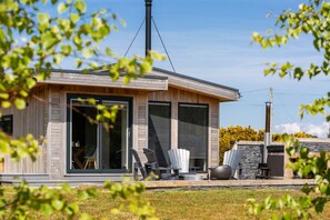 A modern house with large windows, a chimney, and outdoor seating. - Auchrannie Resort (Isle of Arran)