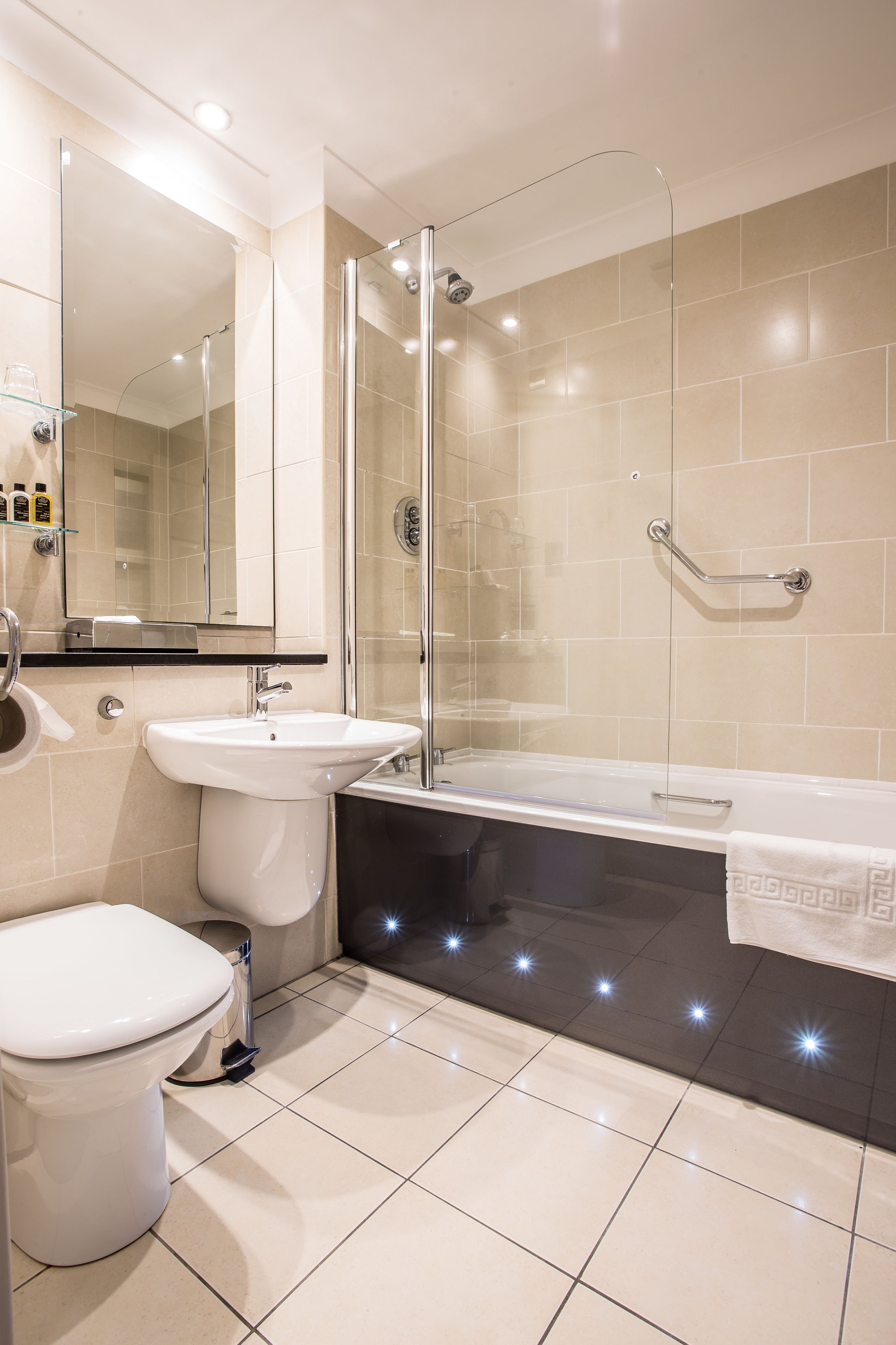A modern bathroom with a glass-enclosed shower, a white sink, and a bathtub.