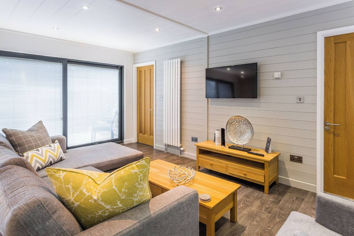 A modern living room with a sofa, coffee table, and TV.