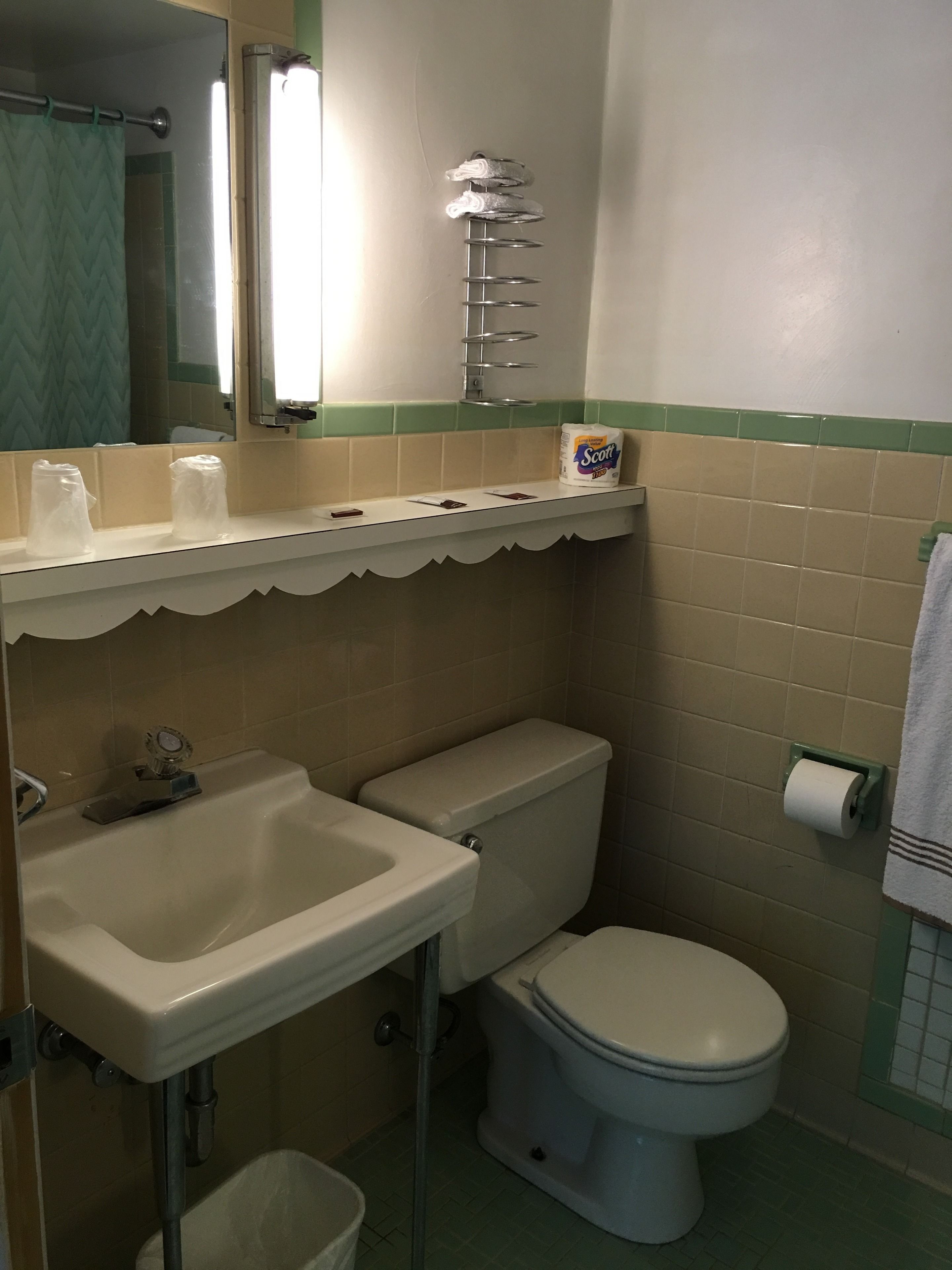 Een badkamer met een wastafel, toilet en een handdoekhouder.