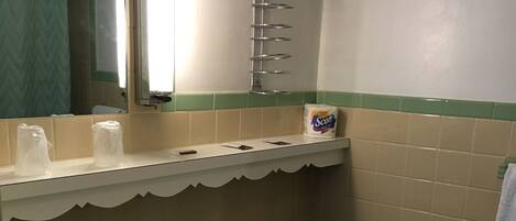 Een badkamer met een wastafel, toilet en een handdoekhouder.