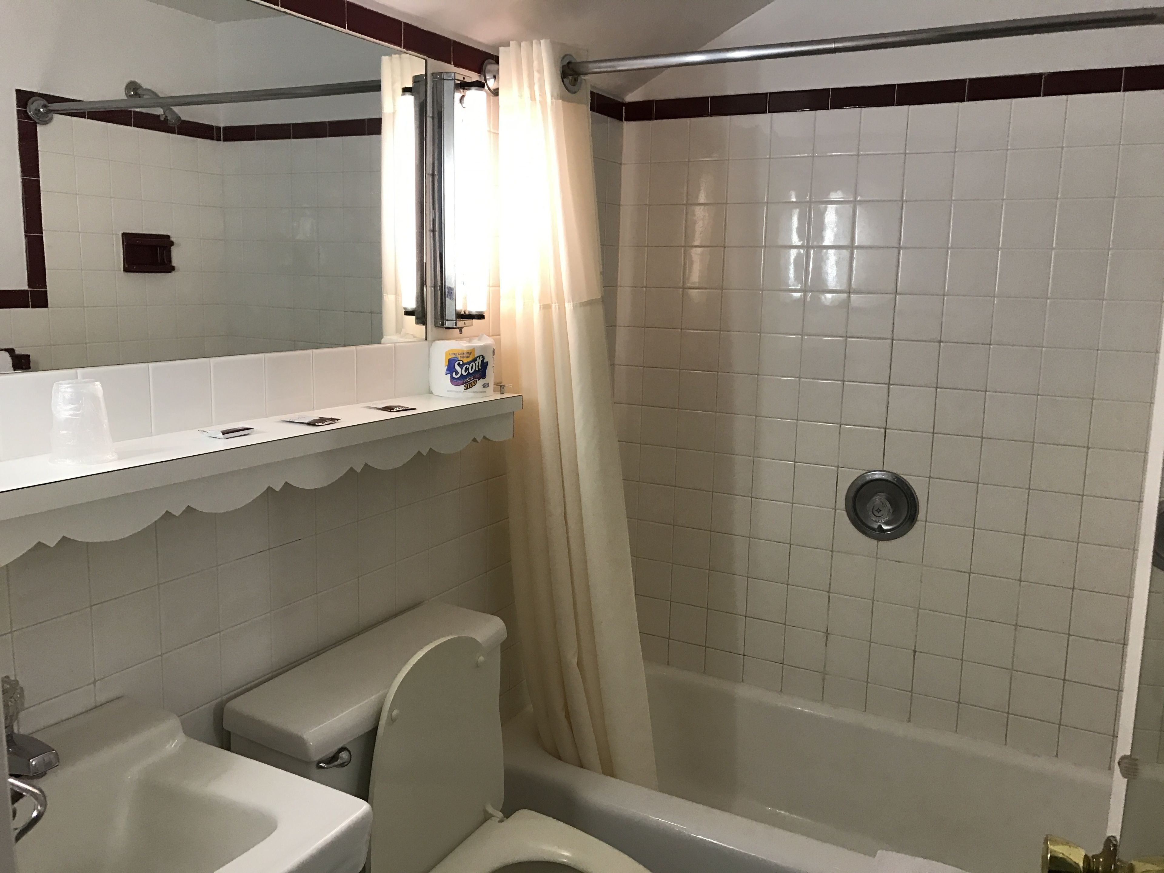 A bathroom with a toilet, sink, and shower area.