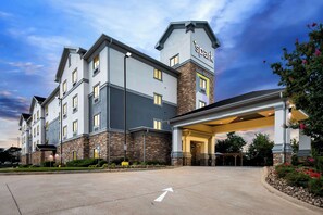 A hotel with a modern design, featuring a prominent 'spark' sign on the building.