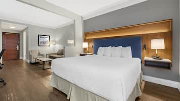Une chambre d’hôtel moderne équipée d’un grand lit, d’un bureau, d’une chaise et d’une petite table.