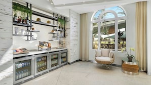 A modern kitchen with built-in refrigerators, shelves with kitchenware, and a large window with a view.