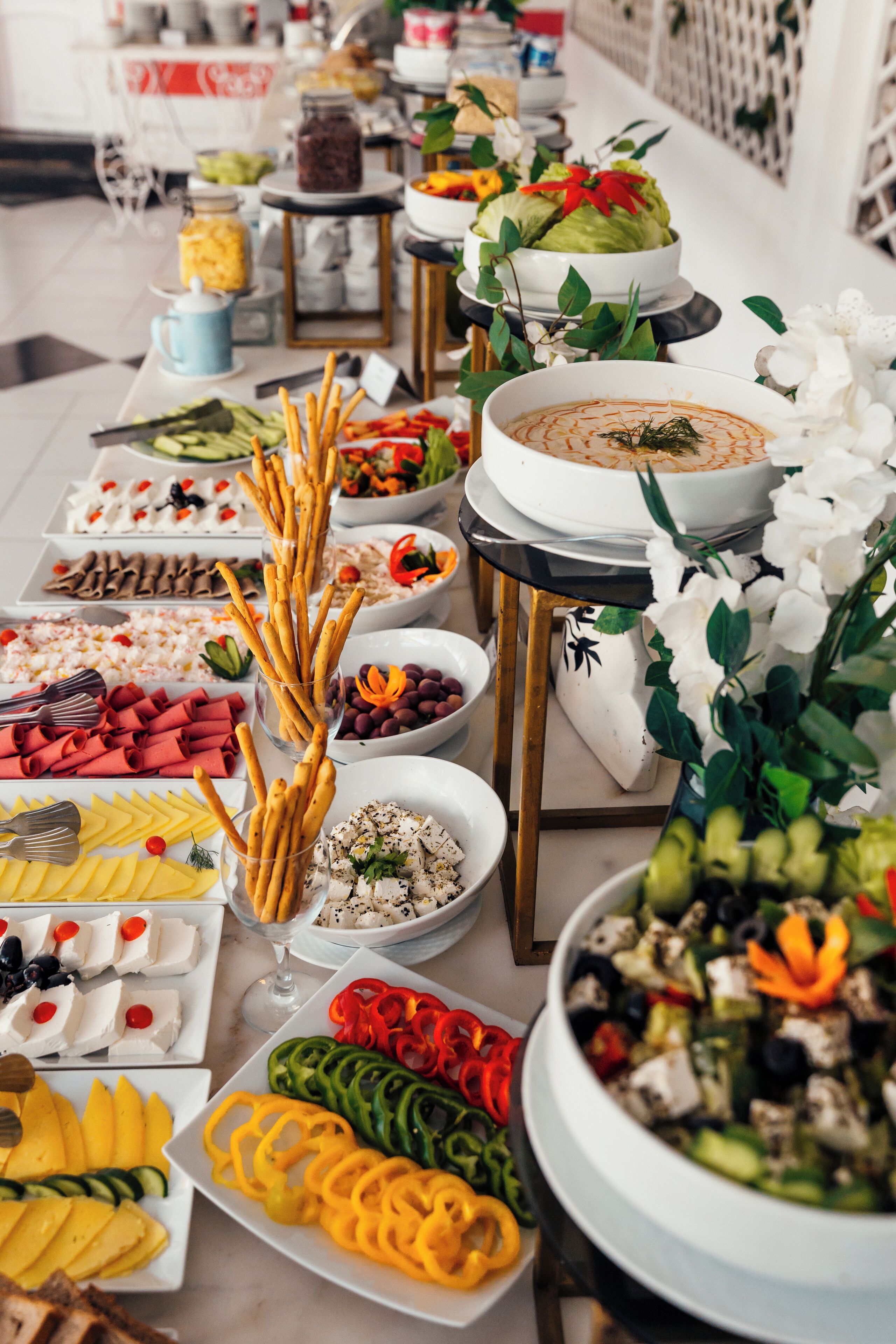 A buffet table with various food items and a large pot of soup.