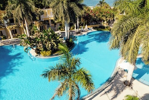 Una piscina techada, una piscina al aire libre, sombrillas