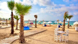 A beach with palm trees, a wooden boardwalk, and beach chairs. - Paradise Inn Beach Resort - Maamoura (Alexandria)