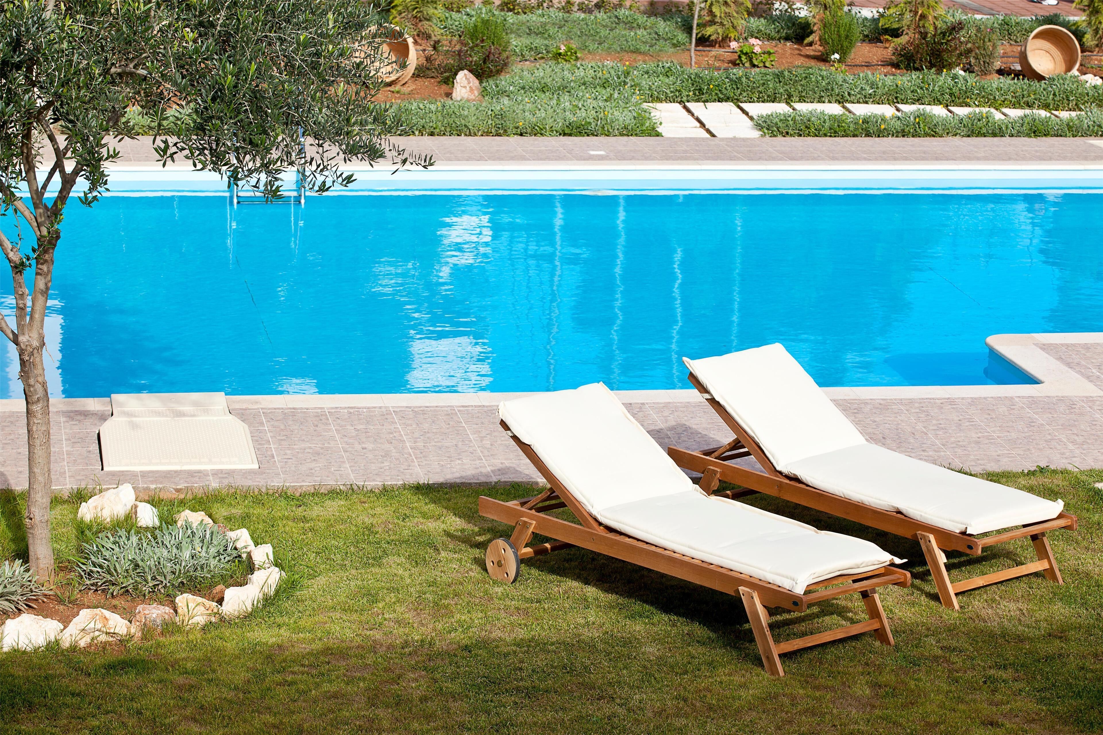 Una piscina al aire libre de temporada, sombrillas
