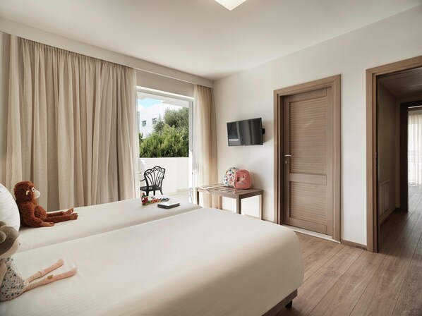A hotel room with two beds, a TV mounted on the wall, a small table with a pink bag, and a window with curtains. - Civitel Attik Rooms & Suites (Marousi)