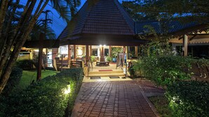 A traditional-style building with a tiled roof, a paved entrance, and surrounding greenery. - Pinnacle Samui Resort SHA Plus (Koh Samui)