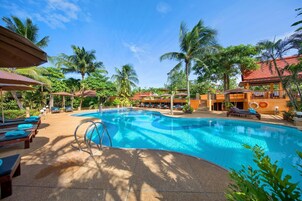Una piscina al aire libre, sillones reclinables de piscina
