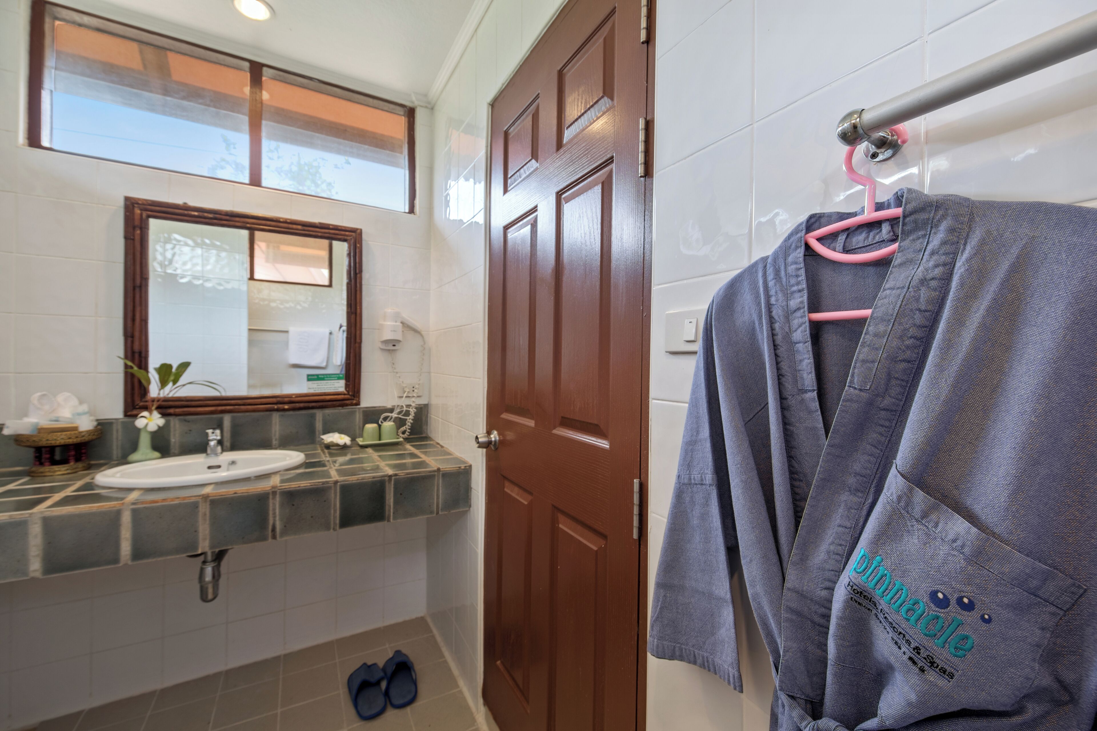 Ein Badezimmer mit Waschbecken, Spiegel und Holztür.