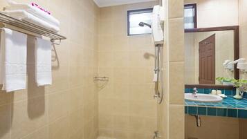 A bathroom with beige tiles, a shower, a sink with a blue countertop, and a towel rack with folded towels.