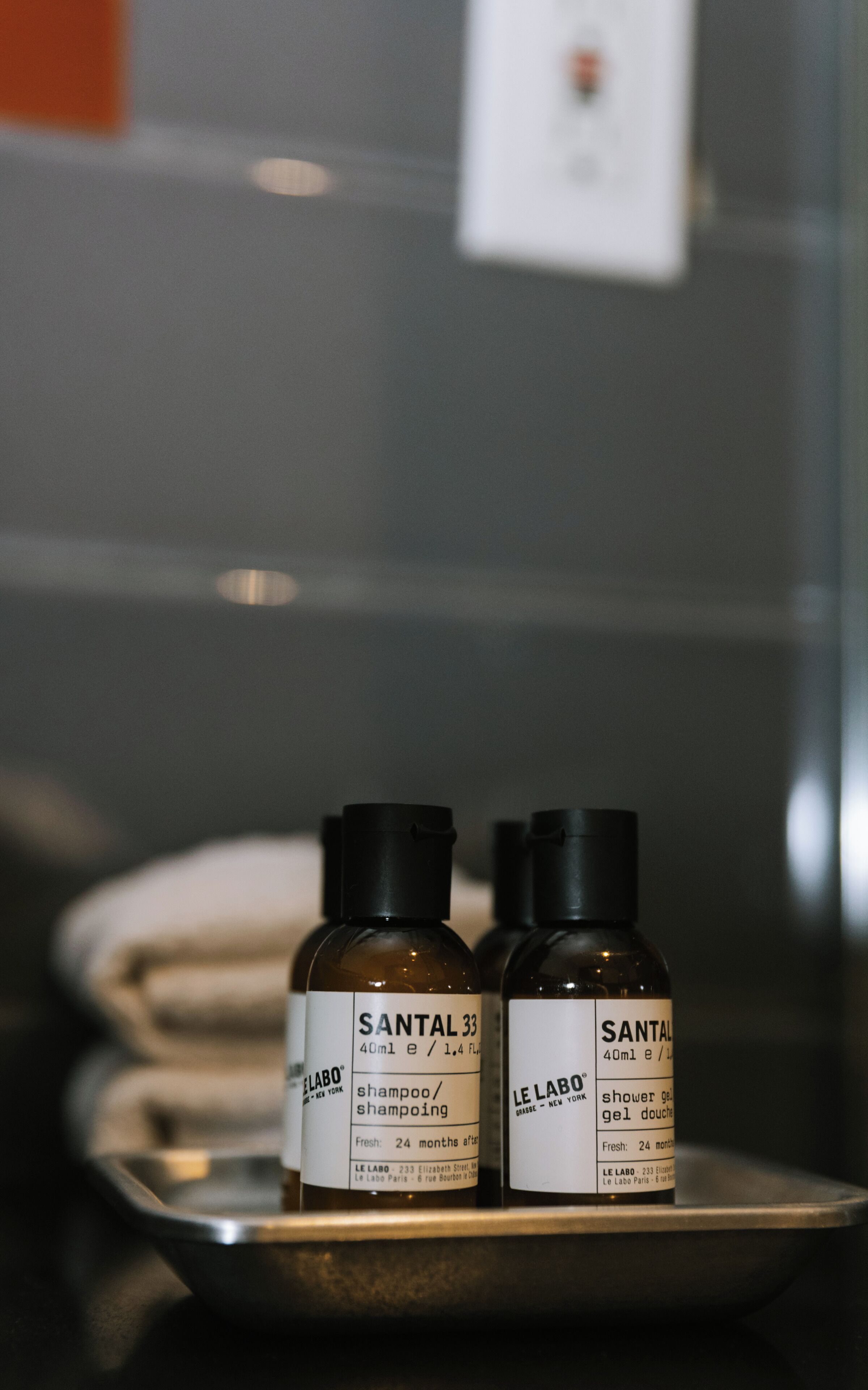 Dos botellas de champú y gel de ducha Santal 33 sobre una bandeja.