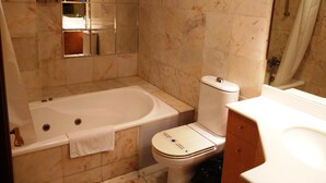 A bathroom with a bathtub, toilet, and a mirror. - Gestión de Alojamientos Rooms - Guest House (Pamplona)
