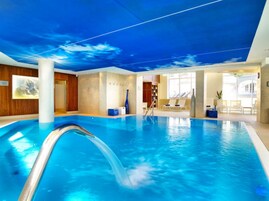 Una piscina techada, sillones reclinables de piscina