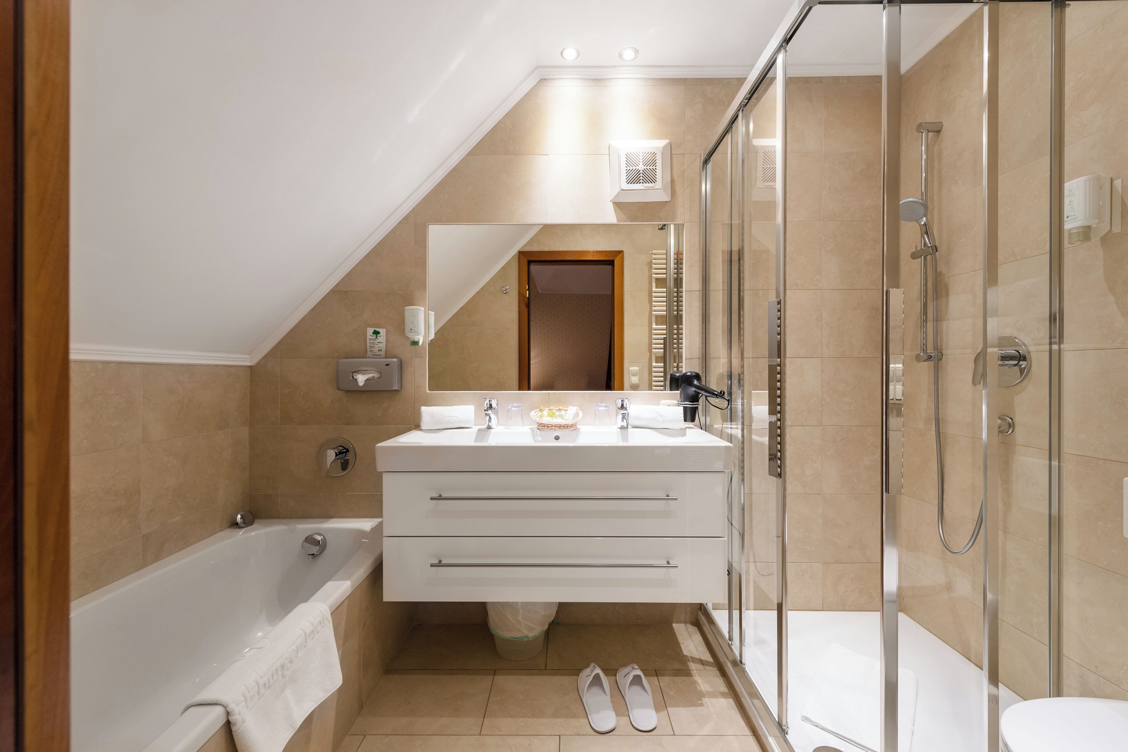 Un baño moderno con bañera, ducha y tocador con espejo.
