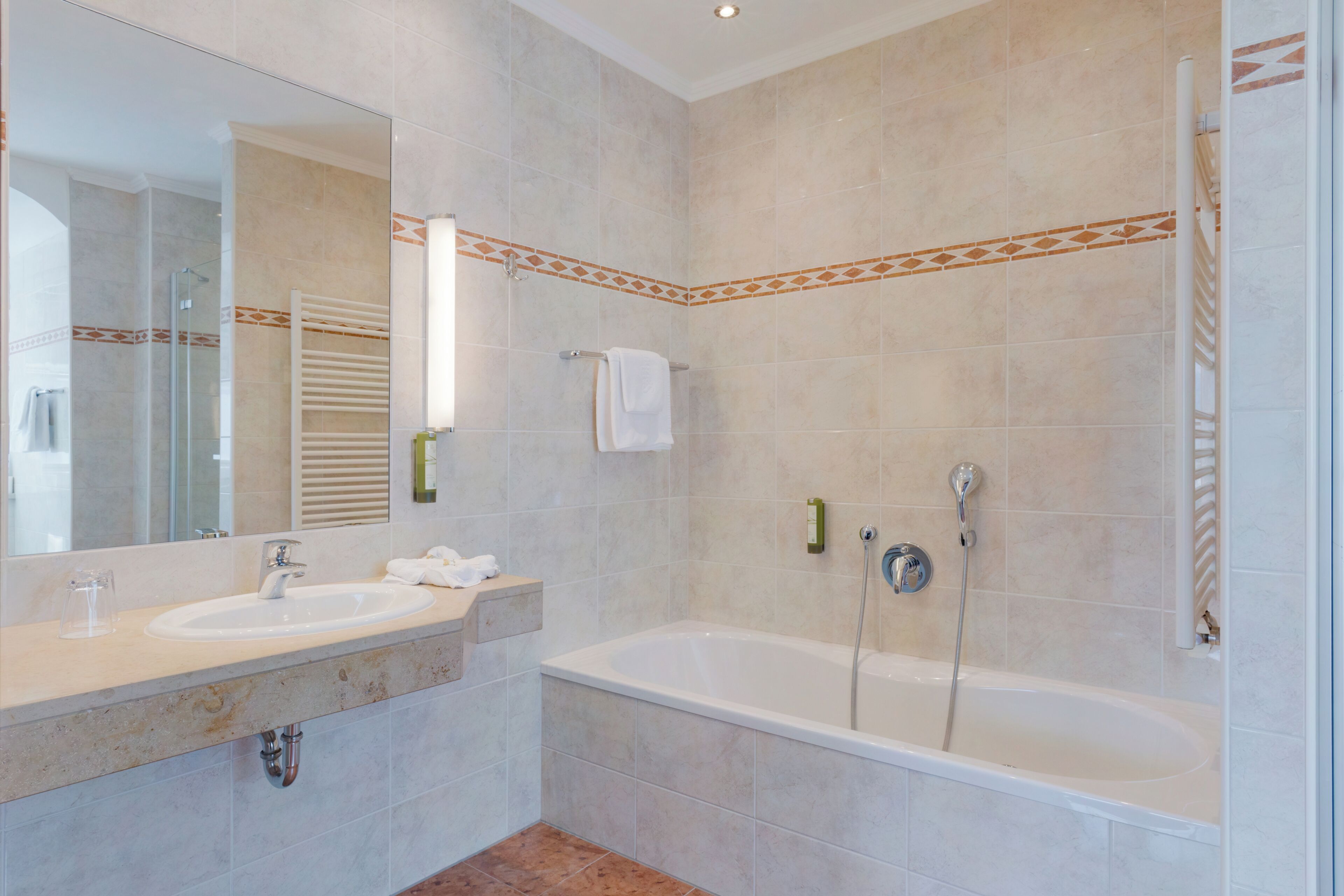 A bathroom with two sinks, a bathtub, and a shower.