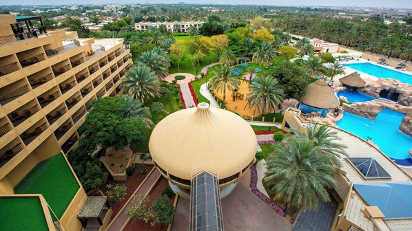 Un hotel con una gran cúpula central, varios balcones y una zona de piscina.