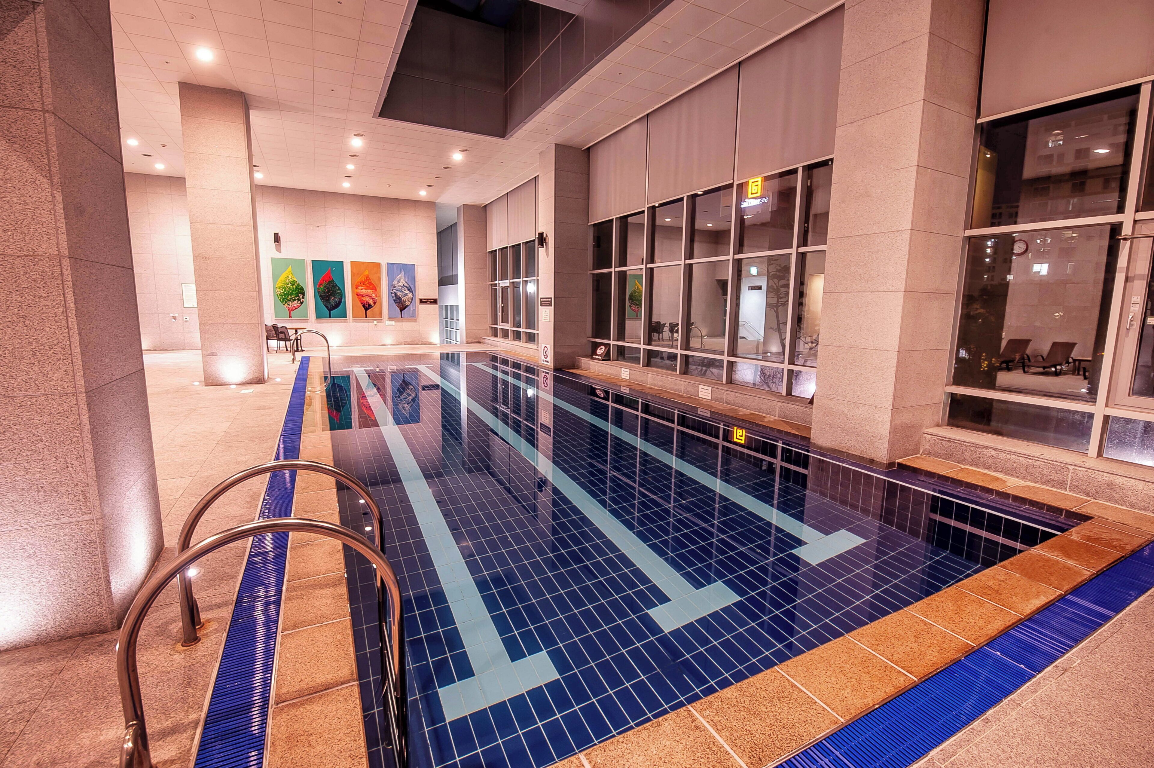 A swimming pool with a tiled floor and a metal ladder.