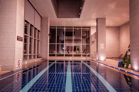 Una piscina techada, sillones reclinables de piscina
