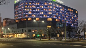 A Holiday Inn hotel with a modern design, featuring a grid of illuminated windows and a prominent green logo. - Holiday Inn Gwangju by IHG (Gwangju)