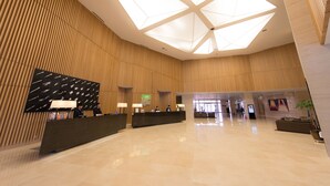 A spacious lobby with a high ceiling, a reception desk, and a modern design. - Holiday Inn Gwangju by IHG (Gwangju)