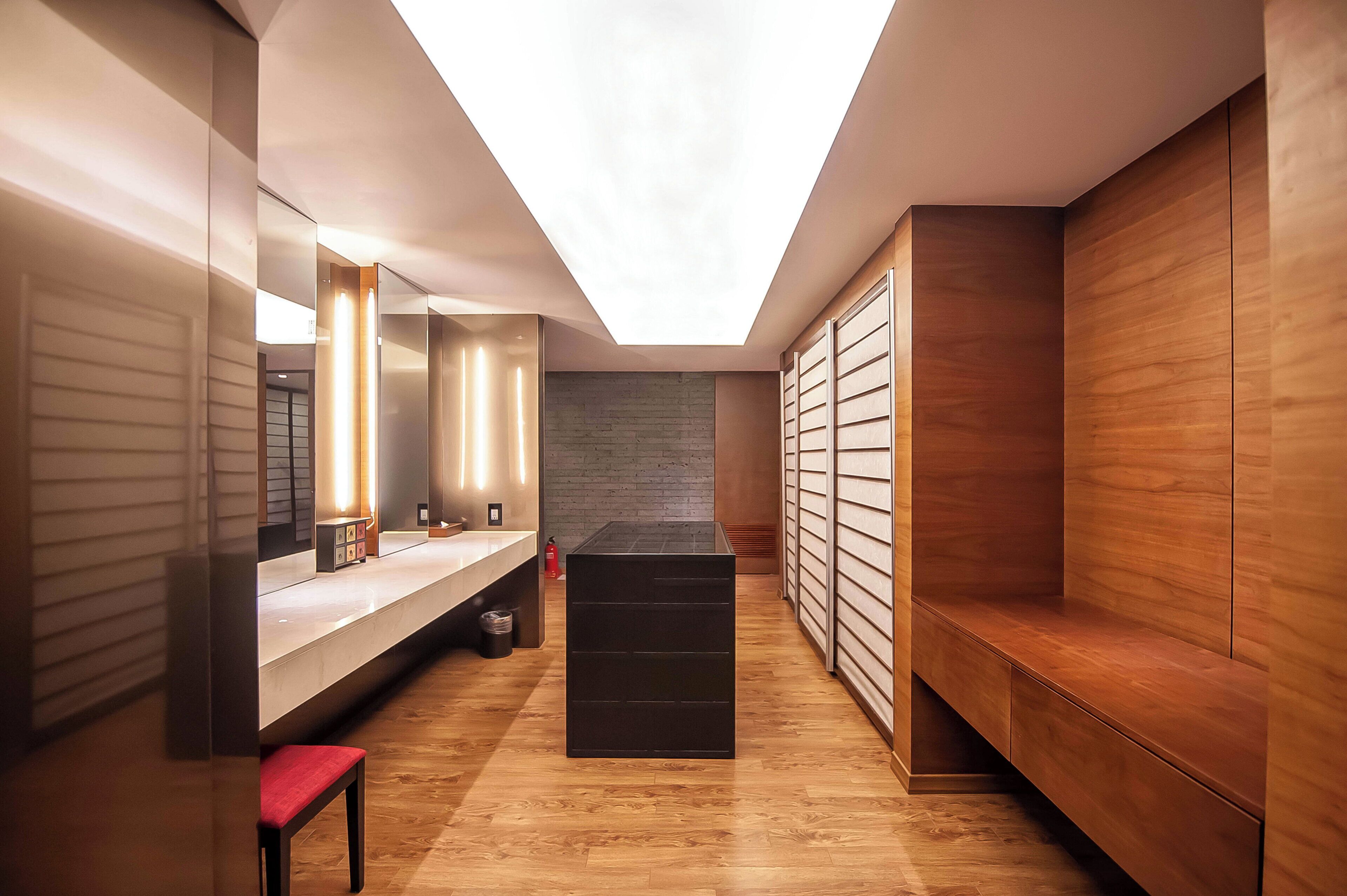 A modern bathroom with a skylight, a vanity with a mirror, and a bench.