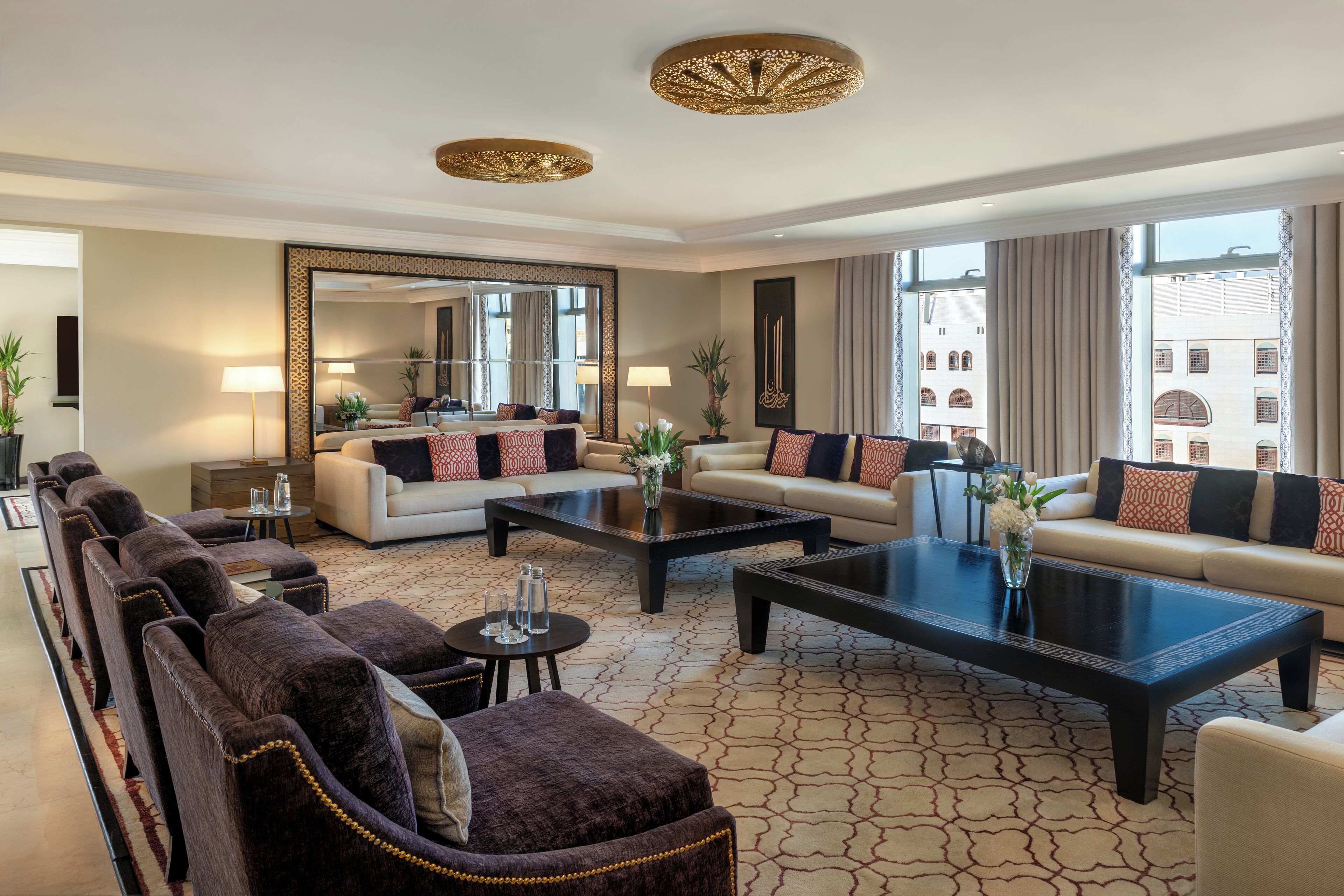 A spacious living room with a sofa set, a coffee table, and a large mirror.