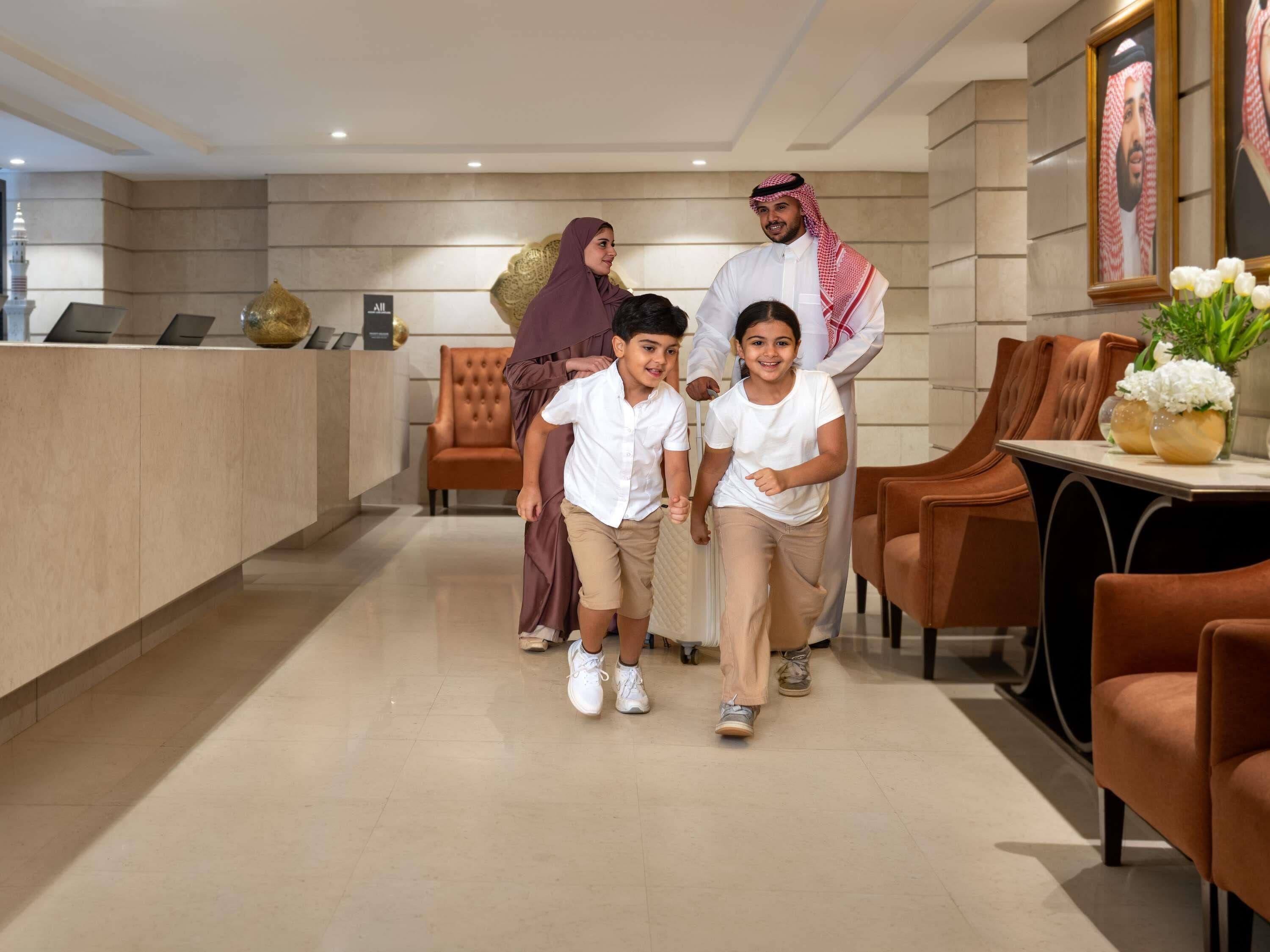 A reception area with a modern design, featuring a reception desk, seating area, and framed portraits on the wall.